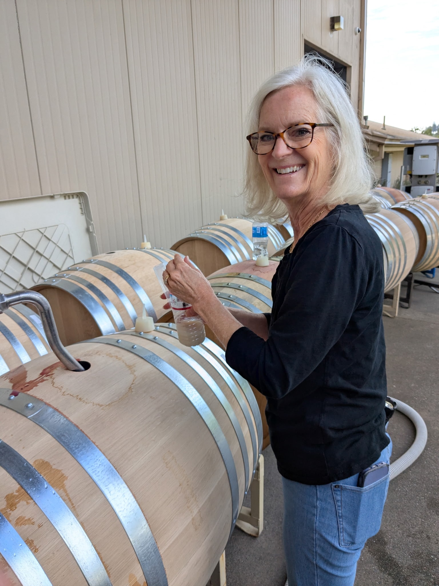 Laura tending to French oak barrels at George Wine